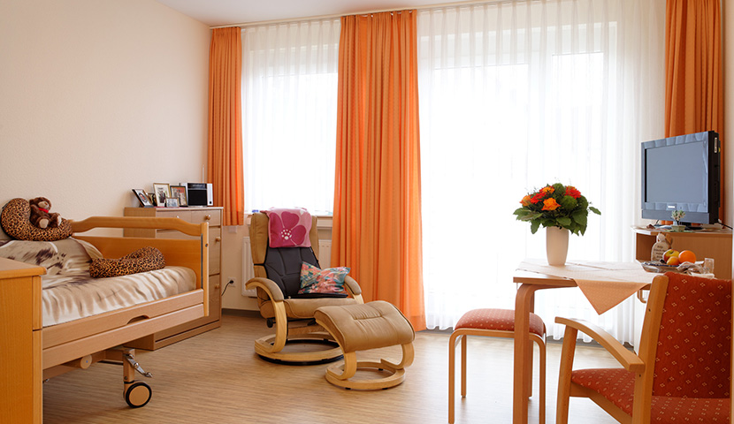 Bewohnerzimmer mit Bett und Sitzecke
