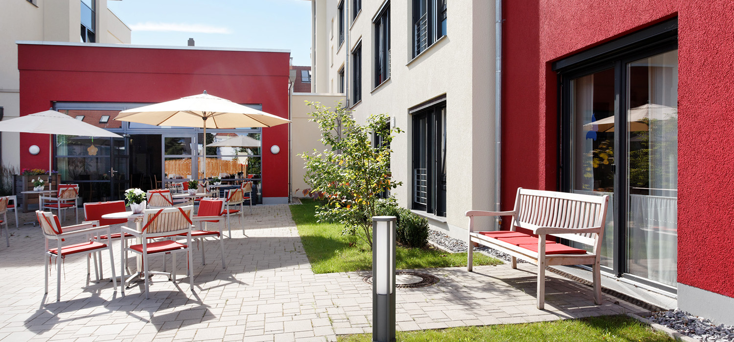 Innenhof des Seniorenzentrums Elisabethstraße mit Sitzgelegenheiten und Sonnenschirmen