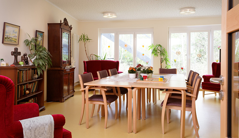 Das Wohnzimmer mit großem Tisch und gemütlichen Sesseln