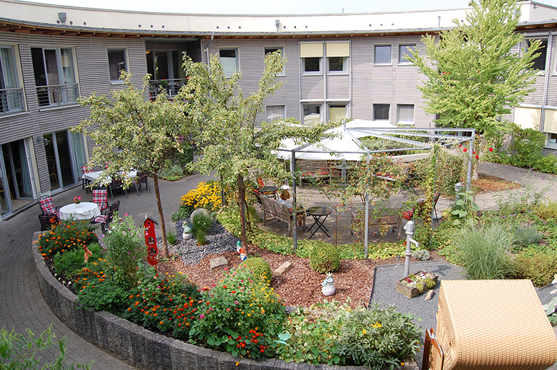 Seniorenzentrum Grüner Weg - Außenansicht des rundgebauten Innenhofs mit Garten