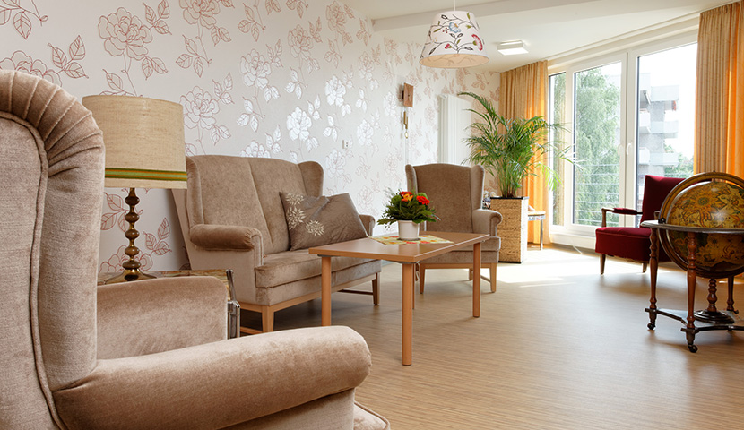 Wohnzimmer mit Sitzgarnitur und Blick in den Garten