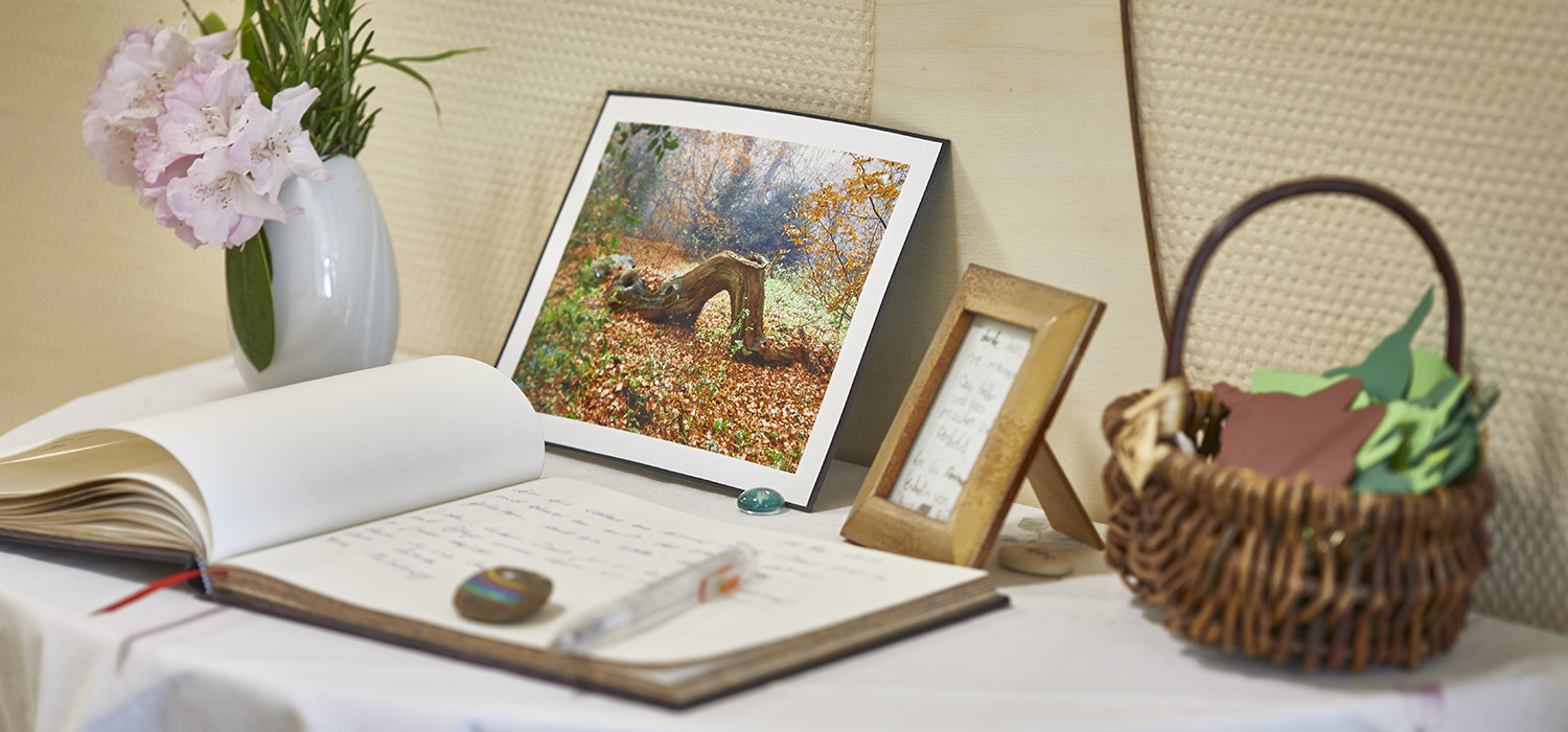 Stillleben mit Gästebuch, Herbstbild, Blumenvase und Korb mit Herbstblättern