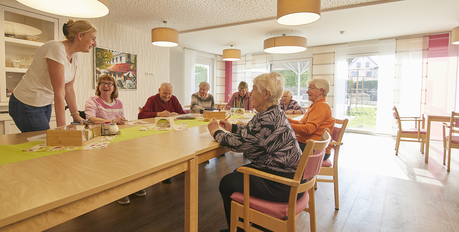 Basteln in der Wohnküche mit Anleitung einer Pflegekraft