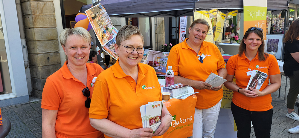 Vier Mitarbeiterinnen verteilen Tagespflege-Infos auf dem Markt in Detmold