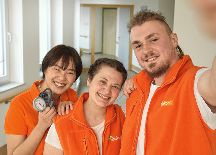 Selfie von drei Auszubildenden in diakonis-Kleidung