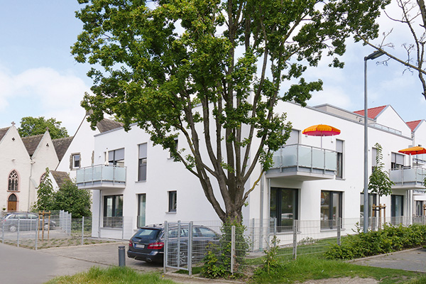 Gebäude Wohngemeinschaft Lage mit Baum im Vordergrund